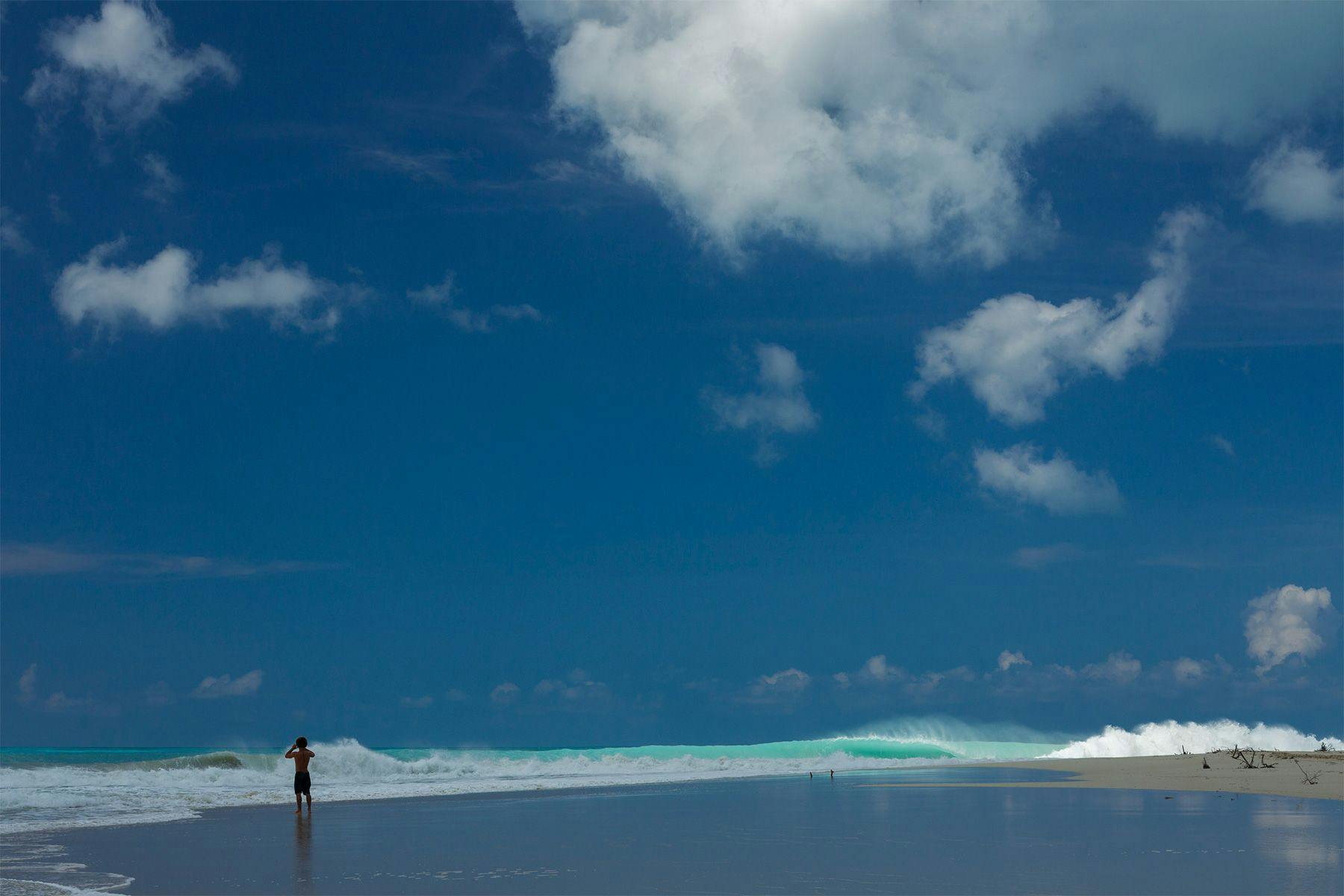 Surfer Alex Botelho watching the waves under stormy skies at Palmetto Point. Photograph by Al Mackinnon..