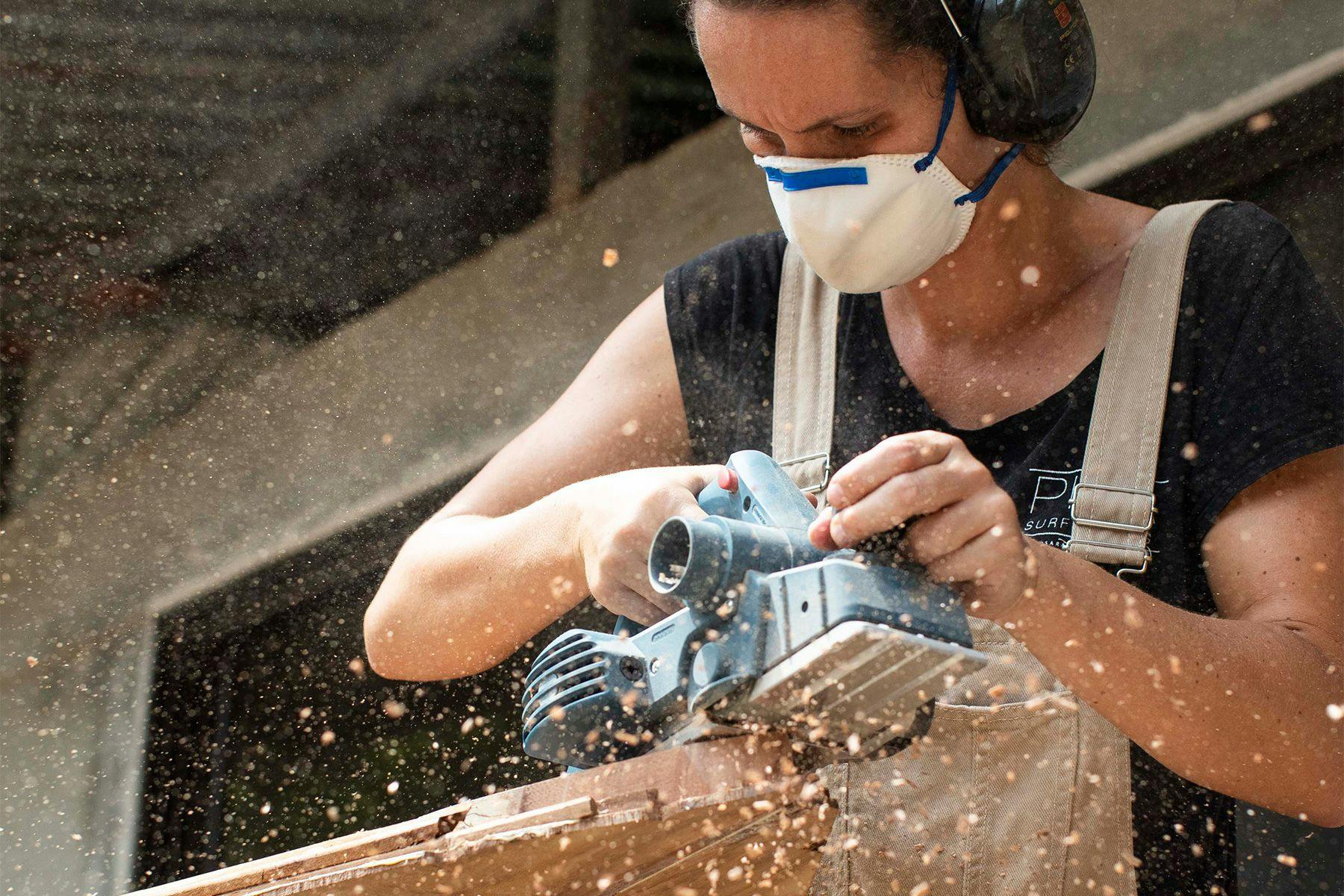 wooden surfboard make marcelina craig of piña surfboards planing the nose of a wooden surfboard