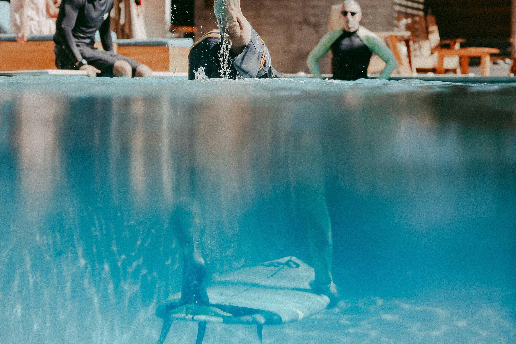 practising duck diving a surfboard in the pool at surf simply resort in costa rica