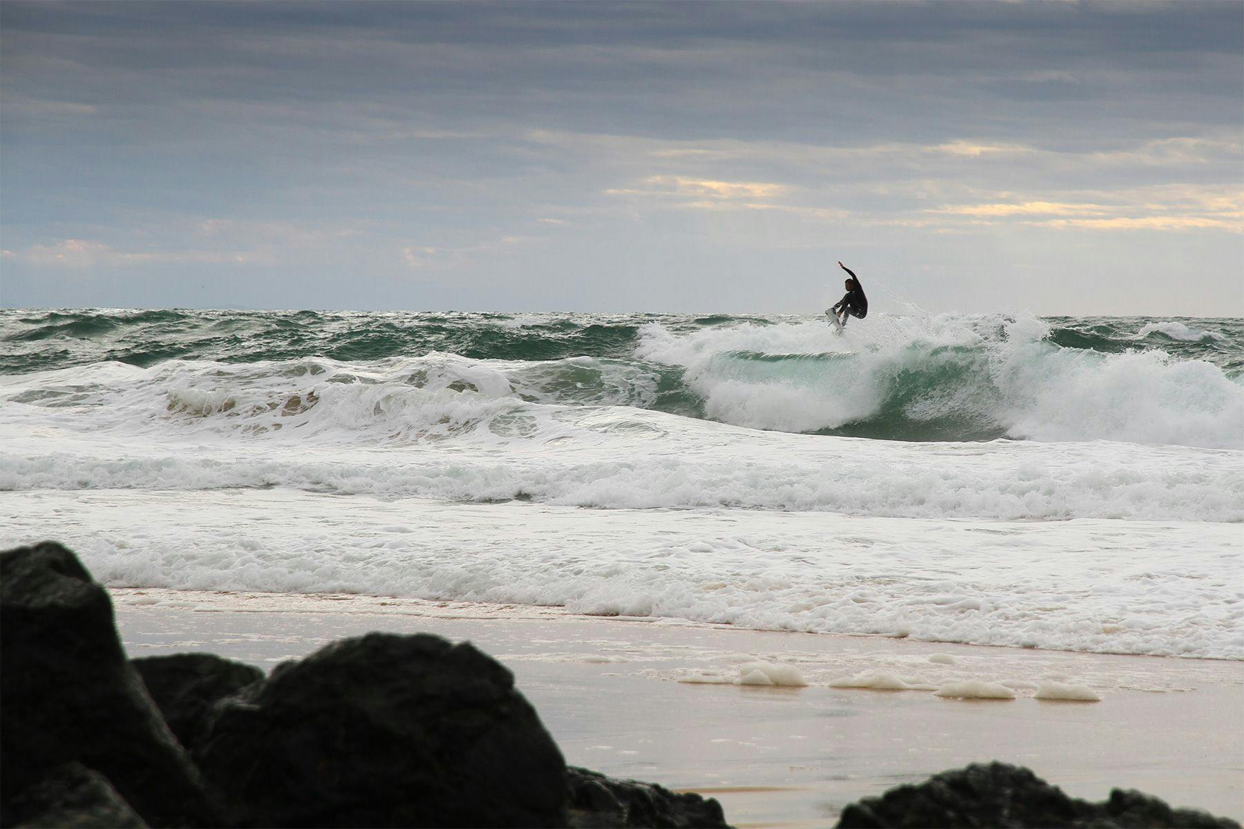 surfer dane reynolds launching a straight grab air in messy conditions in hossegor