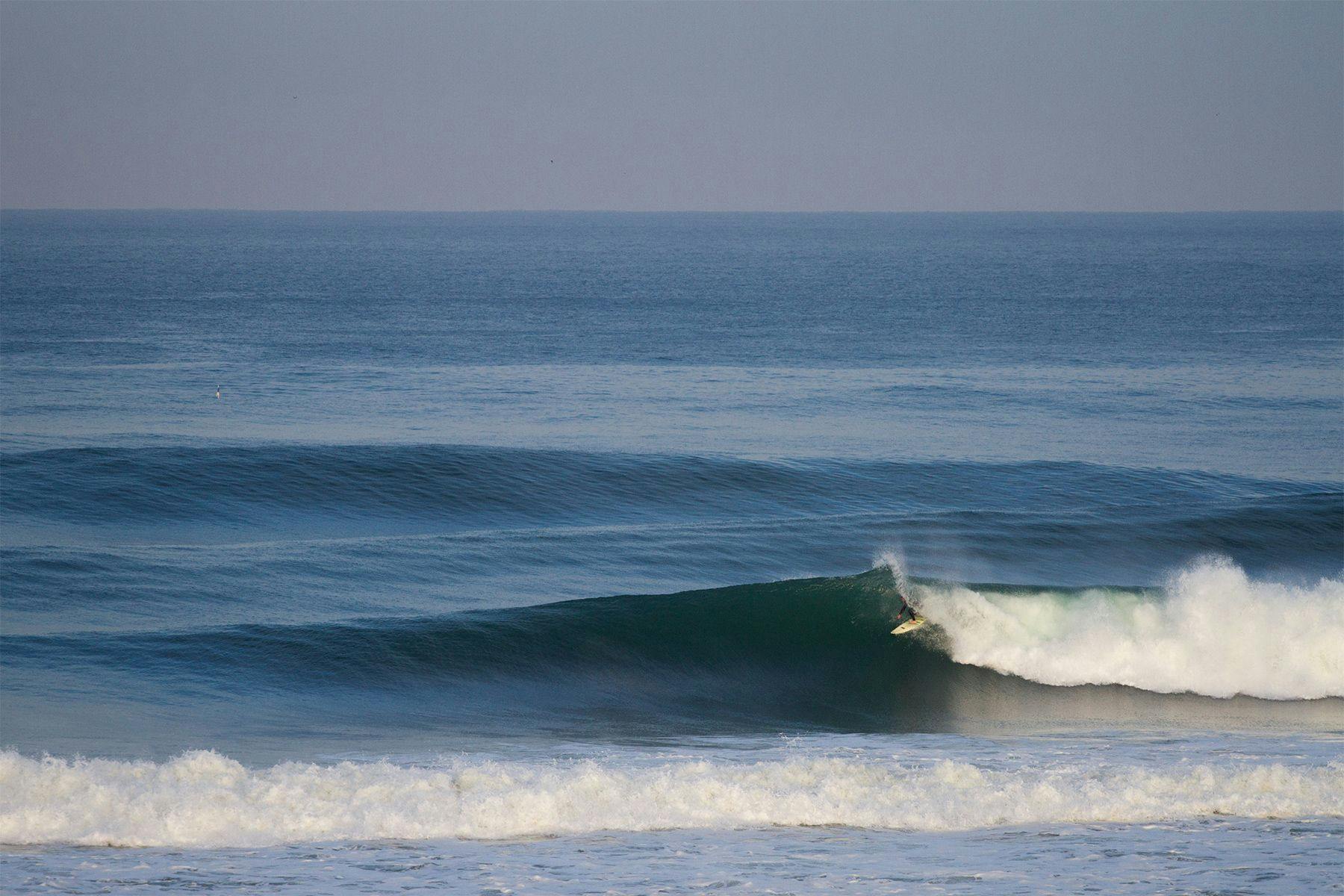 surfer getting barrelled on a large right hand wave