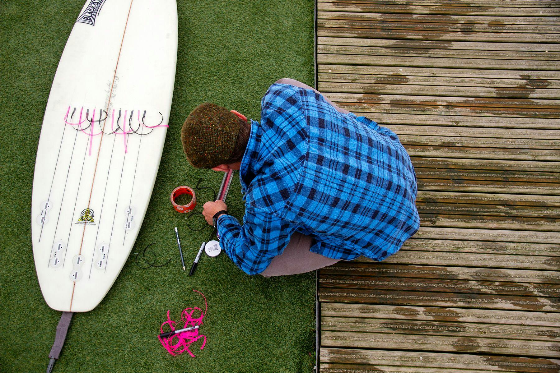 surf simply director of coaching harry knight sticking multicoloured telltale ribbons to the bottom of his surfboard for an experiment