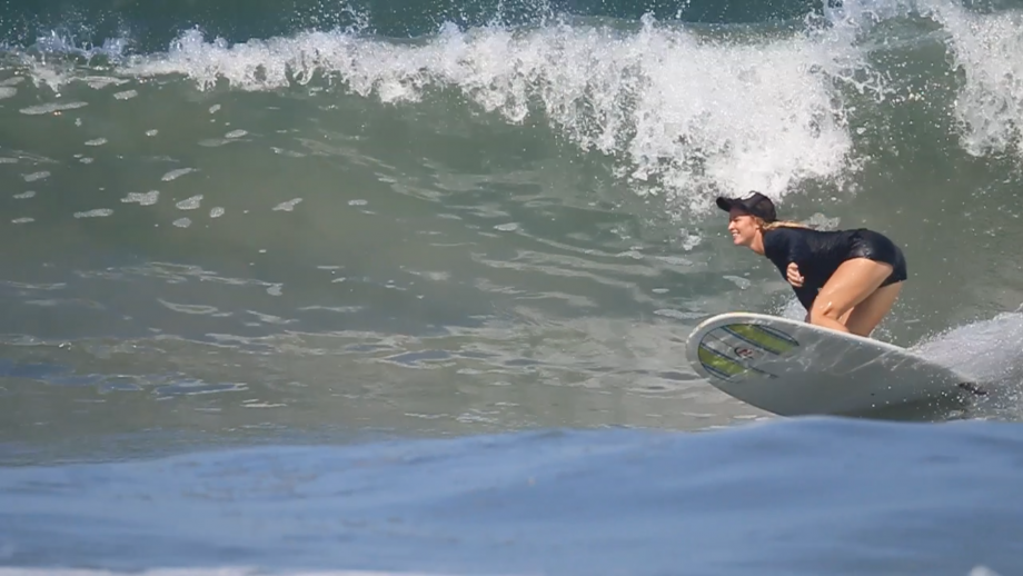 Surf Simply’s Head Coach, Jessie, putting her longboard on rail as she bottom turns. Check the spray coming off her rail, and remember that is all being converted to forwards thrust.